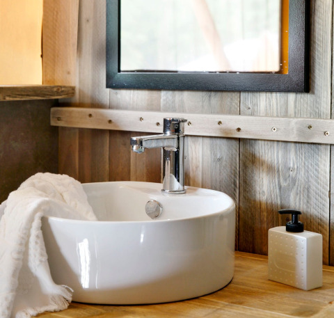 Lavabo moderno con rubinetto cromato, asciugamano bianco e dispenser di sapone presso Buitenplaats Beekhuizen - Glamping Veluwe.