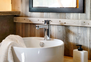 Lavabo moderno con rubinetto cromato, asciugamano bianco e dispenser di sapone presso Buitenplaats Beekhuizen - Glamping Veluwe.