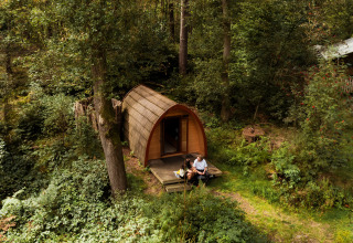 Zwei Personen sitzen vor einer Glamping-Unterkunft bei Buitenplaats Beekhuizen - Glamping Veluwe im Wald.