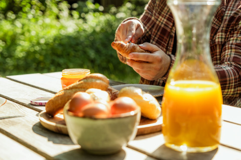 Outdoor breakfast with croissants, eggs, and juice at Buitenplaats Beekhuizen - Glamping Veluwe.