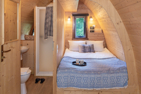 Cozy glamping accommodation at Buitenplaats Beekhuizen, Veluwe, with wooden walls, double bed and bathroom.