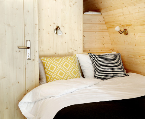 Hébergement glamping confortable à Buitenplaats Beekhuizen - Glamping Veluwe avec murs en bois et coussins douillets.