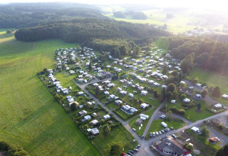 Aerial view of Camping im Bergischen Land - Bauwagen Noordrijn-Westfalen, surrounded by fields and forest.