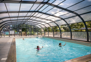 Overdekt zwembad met kinderen bij Huttopia Wattwiller - Glamping Grand Est, een glampingaccommodatie in Frankrijk.