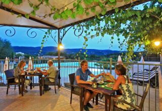 Due coppie cenano romanticamente vicino alla piscina con vista sulle montagne al Domaine de Sévenier & Spa.