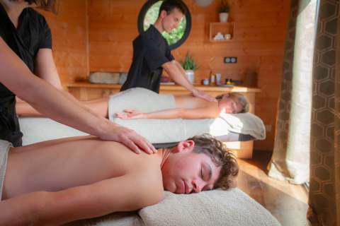 Couple profitant d’un massage relaxant dans un chalet en bois à Domaine de Sévenier & Spa en Auvergne-Rhône-Alpes.
