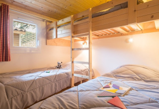 Chambre chaleureuse avec lits simples et lits superposés au Domaine de Sévenier & Spa, Auvergne-Rhône-Alpes.