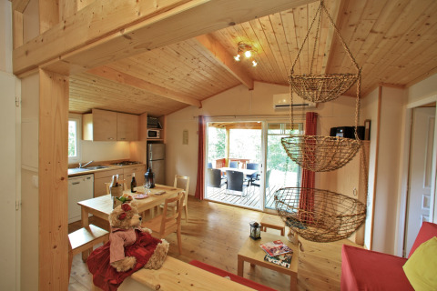 Interior of a cozy chalet at Domaine de Sévenier & Spa, featuring wood décor and a dining area in France.