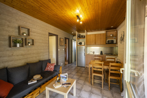Vista interna di uno chalet glamping accogliente con cucina moderna e soggiorno in Auvergne-Rhône-Alpes.