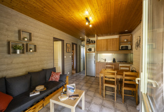 Vista interna di uno chalet glamping accogliente con cucina moderna e soggiorno in Auvergne-Rhône-Alpes.