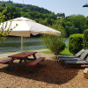 Glamping at Camping Fortuna am Neckar with picnic table, loungers, and gypsy wagon by the river in Baden-Württemberg.