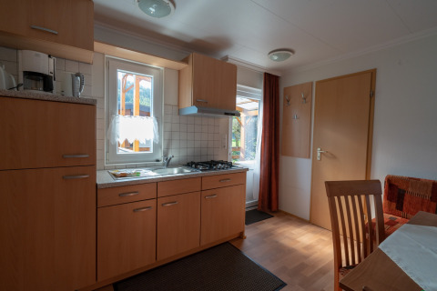 Moderne glampingkøkken i Camping Hetzingen - Stacaravans Nordrhein-Westfalen med træmøbler og vinduer.