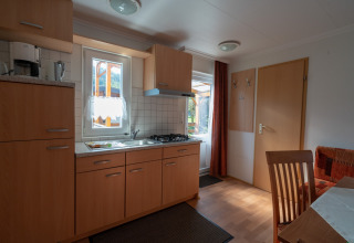 Cocina moderna de glamping en Camping Hetzingen - Stacaravans Nordrhein-Westfalen con muebles de madera.