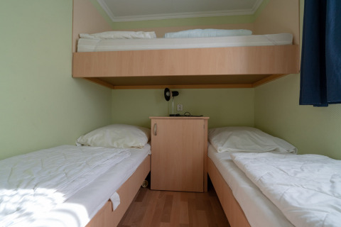 Kamer met eenpersoonsbedden en stapelbed bij Camping Hetzingen - Stacaravans Noordrijn-Westfalen, glamping.