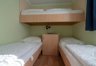 Zimmer mit Einzelbetten und Etagenbett in Camping Hetzingen - Stacaravans Noordrijn-Westfalen, Glamping.