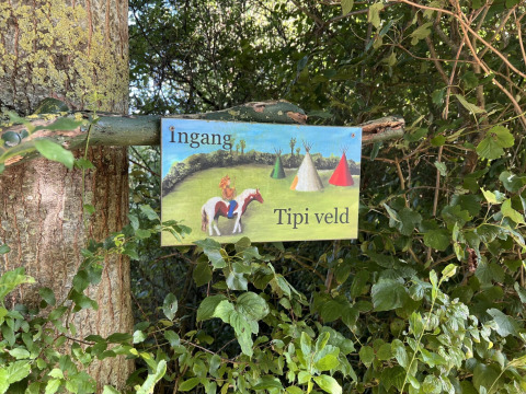 Cartello nella natura con 'Ingang Tipi veld' per Glamping - De Bokkesprong, Olanda, area tende tipi.