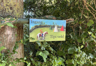 Forest sign saying 'Ingang Tipi veld' for Glamping - De Bokkesprong in the Netherlands, tipi field area.