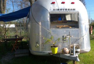 Vintage Airstream caravan in Thüringen omgetoverd tot glampinghotel met een gezellige buitenomgeving.