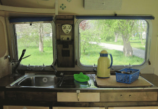 Keuken in een vintage caravan bij Airstream Hotel - Vintage Caravan Thüringen met uitzicht op het groen.