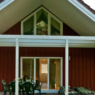 Holiday house at Vakantiepark Havelberge in Mecklenburg-Vorpommern with terrace, outdoor seating, and trees.