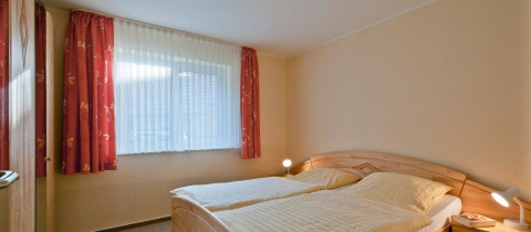 Chambre avec deux lits jumeaux et fenêtre ensoleillée au glamping Vakantiepark Havelberge en Mecklembourg-Poméranie.