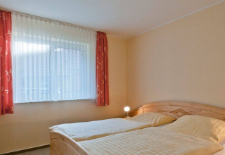 Camera con due letti singoli e finestra luminosa presso il glamping Vakantiepark Havelberge in Meclemburgo-Pomerania.