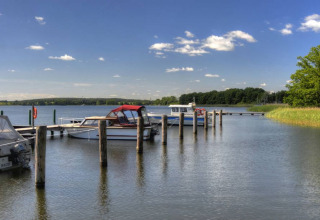 Des bateaux amarrés près d’un ponton à Vakantiepark Havelberge, au bord de l’eau en Mecklembourg.