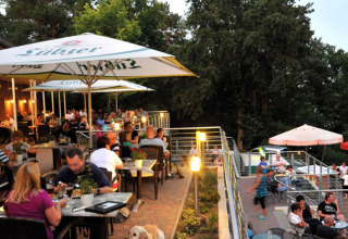 Außenbereich eines Restaurants im Vakantiepark Havelberge in Mecklenburg-Vorpommern mit Gästen.