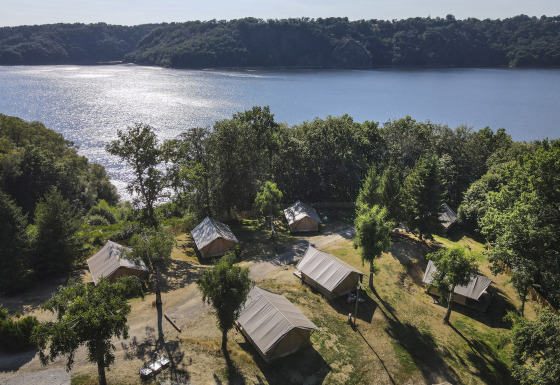 Glamping tenten aan het meer bij Huttopia Lac de la Siauve - Glamping Auvergne, omgeven door bos en natuur.