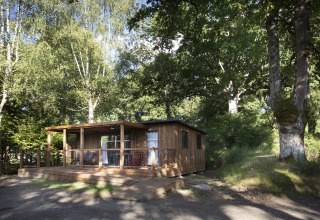 Wooden glamping cabin in a forested setting at Huttopia Lac de la Siauve, Auvergne, France.