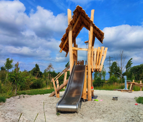 Aire de jeux avec maisonnette en bois et toboggan au glamping Stadslandgoed De Heicohoeve, Gelderland.