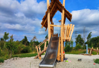 Aire de jeux avec maisonnette en bois et toboggan au glamping Stadslandgoed De Heicohoeve, Gelderland.