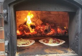 Brændefyret pizzaovn til udendørs madlavning på Stadslandgoed De Heicohoeve - Glamping Lodges Gelderland.