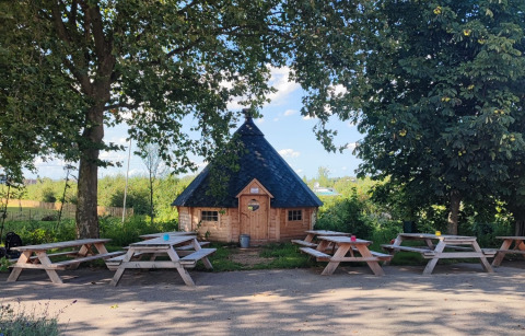 Alloggio glamping in casetta di legno presso Stadslandgoed De Heicohoeve, Gelderland, con tavoli da picnic.