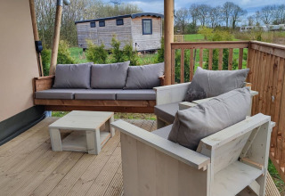 Gemütliche Terrasse mit Holzmöbeln bei Stadslandgoed De Heicohoeve - Glamping Lodges Gelderland.