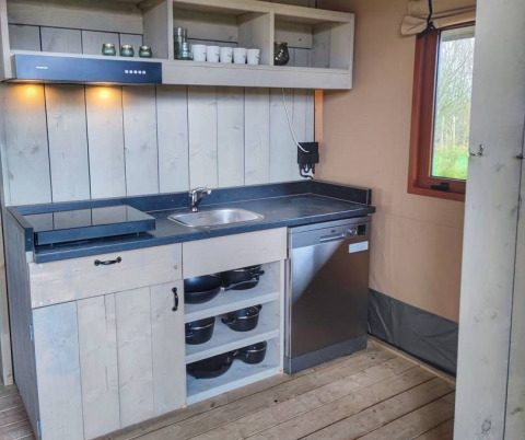 Moderne glamping keuken in Stadslandgoed De Heicohoeve met kookplaat, spoelbak en vaatwasser.