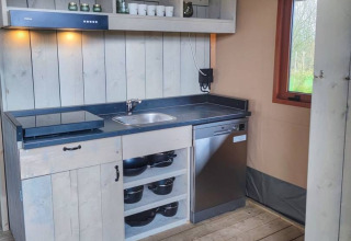 Moderne glamping køkken i Stadslandgoed De Heicohoeve med elkomfur, opvaskemaskine og udsigt.