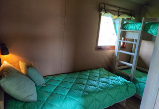 Interno di una confortevole tenda glamping con letto singolo e letto a castello a Gelderland.