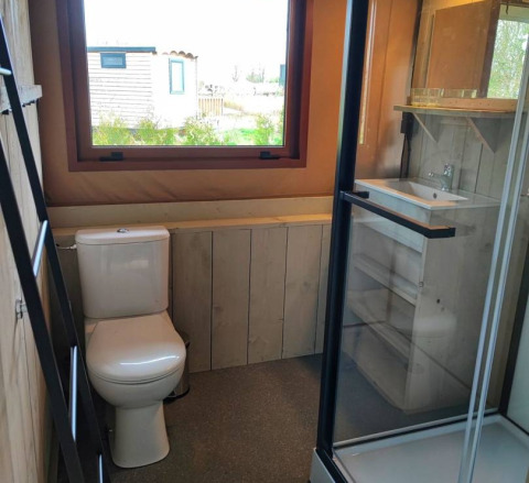 Bagno moderno con wc, doccia e lavandino in una sistemazione glamping presso Stadslandgoed De Heicohoeve.