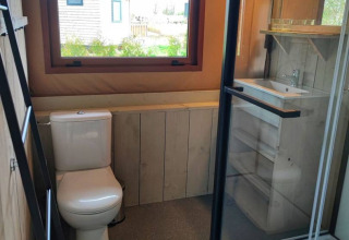 Moderne badkamer met toilet, douche en wastafel in een glamping lodge bij Stadslandgoed De Heicohoeve.