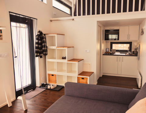 Interieur van Tiny lodge - Ellertshäuser See met compacte keuken, trap, gezellige entree en slaapzolder.