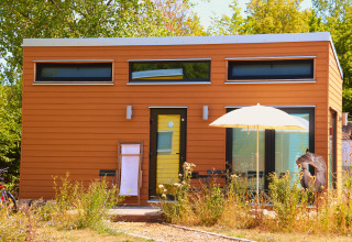 Glampingaccommodatie 'Tiny lodge - Ellertshäuser See', een modern tiny house met zonnig terras en tuin.
