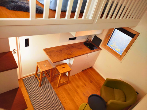 Vista interior de una pequeña cabaña glamping en Ellertshäuser See, equipada con altillo y cocina.