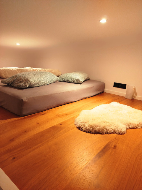 Cozy glamping accommodation at Tiny lodge - Ellertshäuser See, featuring a low bed and soft rug on wood floor.