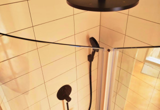 Douche moderne avec robinetterie noire dans le Tiny lodge Ellertshäuser See, salle de bain camping claire.