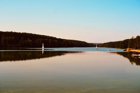 Stille søscene ved Tiny lodge - Ellertshäuser See i Tyskland med sejlskibe og grønne skovomgivelser.