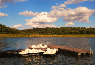 Tiny lodge accommodatie aan Ellertshäuser See met waterfietsen aan een steiger op een zonnige dag.
