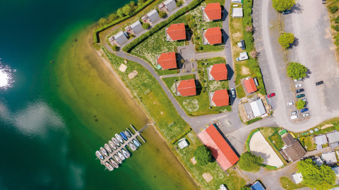 Luchtfoto van Vakantiepark Sorpesee - Boomhutten Noordrijn-Westfalen met huisjes, boten en parkeerplaats.