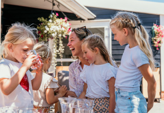 Family enjoys a sunny day outdoors at Strandpark De Zeeuwse Kust - Safaritenten Zeeland glamping site together.