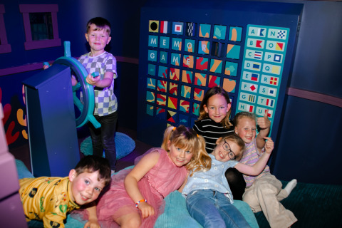 Niños juegan juntos en una zona de juegos interior en Strandpark De Zeeuwse Kust - Safaritenten Zeeland.